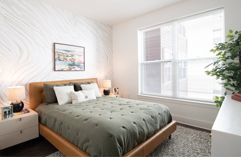 A bedroom with a large bed and a painting on the wall.