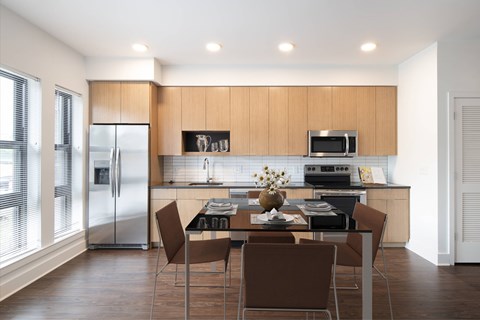 A modern kitchen with a dining table set for four.