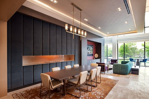 A modern dining room with a long table and chairs.