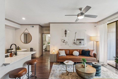 A modern living room with a brown leather couch and a wooden coffee table.