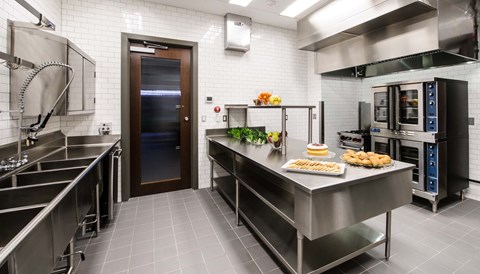 A kitchen with a stainless steel counter and a tray of food on it.
