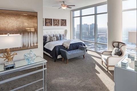 A bedroom with a large bed and a view of the city.