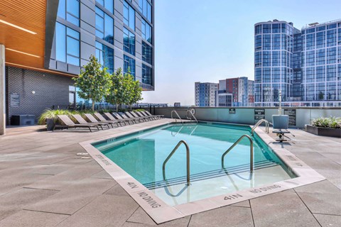 A pool on a rooftop with a building in the background.