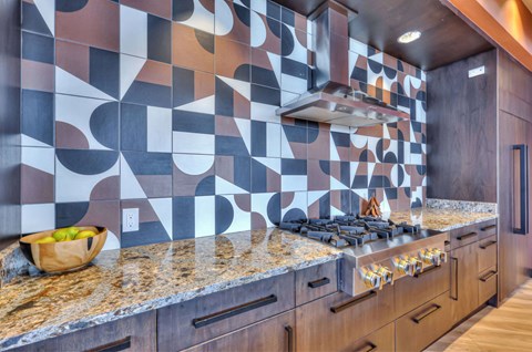 A kitchen with a counter top and a bowl of fruit on it.