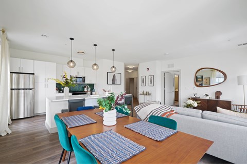 A modern dining room with a wooden table and blue chairs.