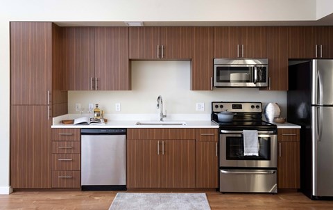 A modern kitchen with wooden cabinets and stainless steel appliances.