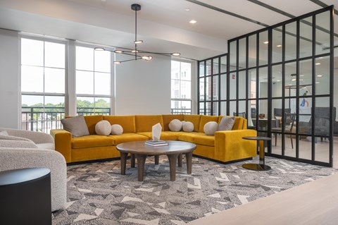 A modern living room with a yellow sofa and a patterned rug.