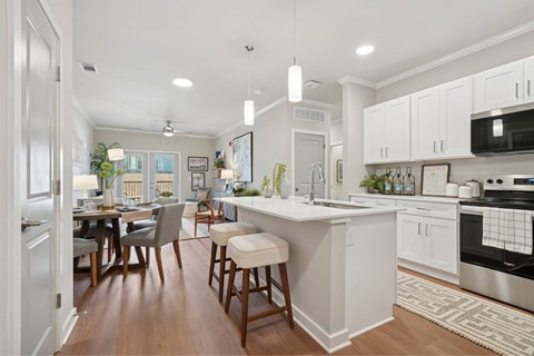 A modern kitchen with white cabinets and a wooden island.