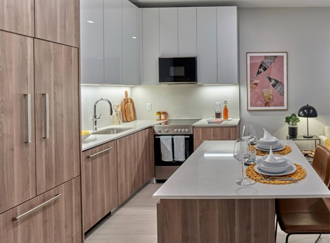 A modern kitchen with a dining table set for two.