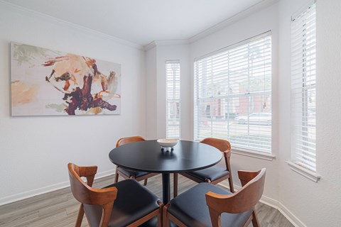A dining room with a table and chairs.