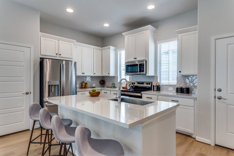 A modern kitchen with a large island and stainless steel appliances.