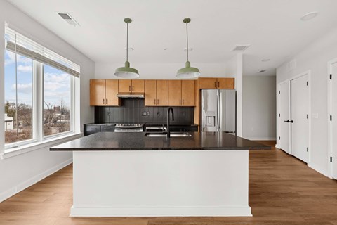 A modern kitchen with wooden cabinets and a black countertop.