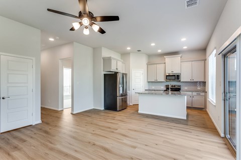 A modern kitchen with a refrigerator, microwave, and oven.