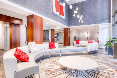 A modern living room with a curved white sofa and a circular coffee table.