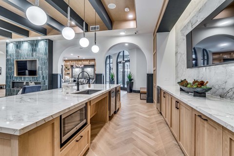 A modern kitchen with wooden cabinets and a marble countertop.