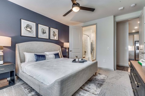 A bedroom with a large bed and a ceiling fan.