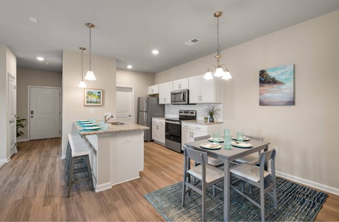 A kitchen with a table set for two with a view of the beach.