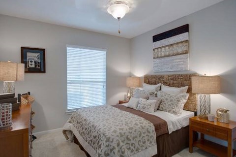 A bedroom with a bed, nightstand, and lamp.