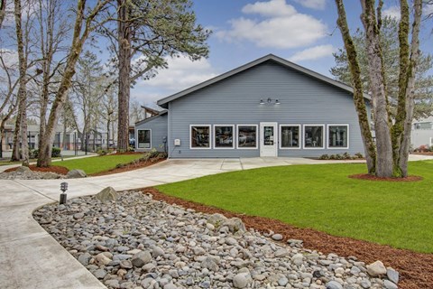 A grey house with a stone pathway leading to the front door.