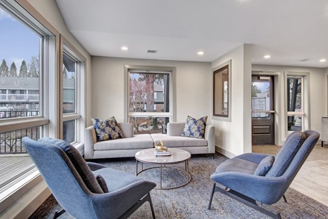 A living room with a blue chair and a white couch.