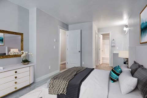 A bedroom with a large bed and a dresser with a mirror.