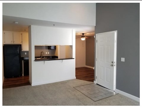 A kitchen area with a refrigerator, microwave, and a countertop with a sink.