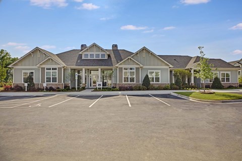 A large house with a parking lot in front.