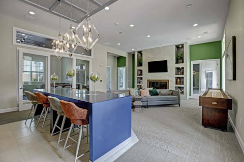 A modern kitchen with a blue island and a dining table with chairs.