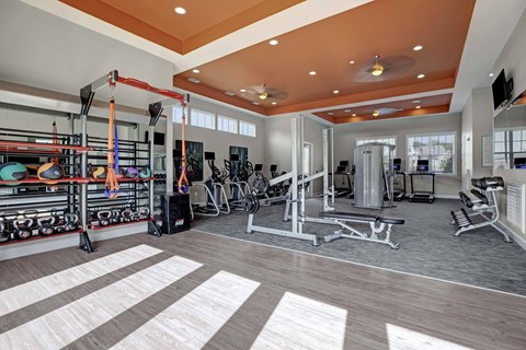 A gym with a variety of equipment including weights and cardio machines.