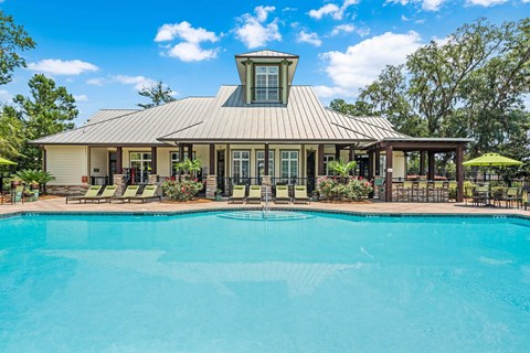 A house with a pool in front of it.