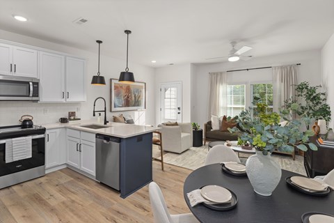 A modern kitchen with a dining table set for two.