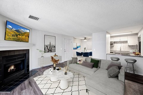 A living room with a fireplace and a painting of a mountain scene on the wall.
