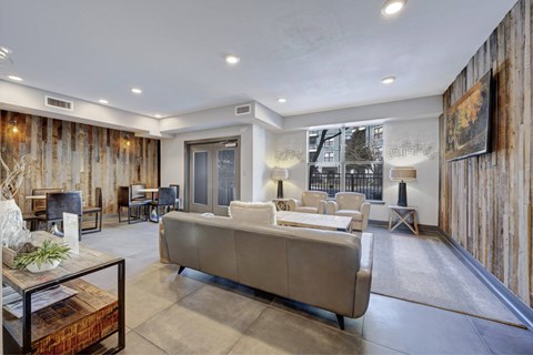 A living room with a couch, a coffee table, and a large window.