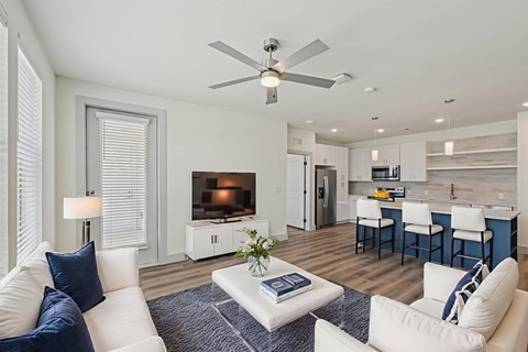A living room with a white couch and a ceiling fan.