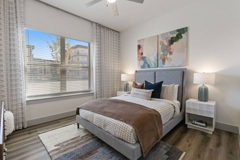 A bedroom with a large bed and a painting on the wall.