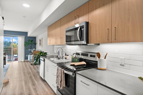 A modern kitchen with wooden cabinets and a black stove top.