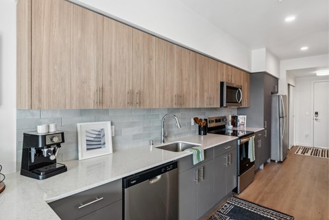 A modern kitchen with wooden cabinets and stainless steel appliances.