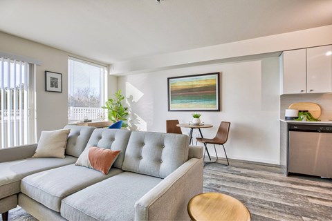 A modern living room with a grey sofa and a wooden table.
