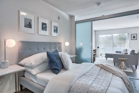 A bedroom with a large bed and a grey headboard.