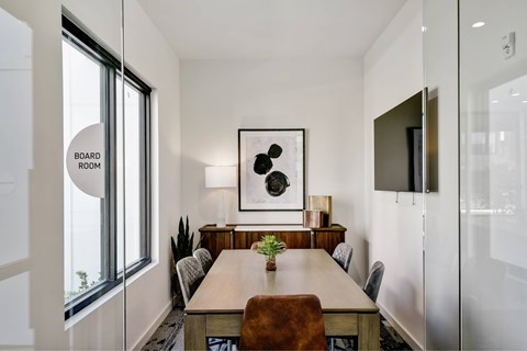 A conference room with a long table and chairs.