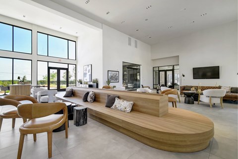 A modern living room with a curved wooden sofa and multiple chairs.