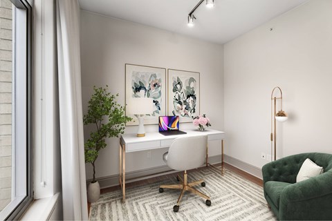 A room with a desk, chair, and potted plant.