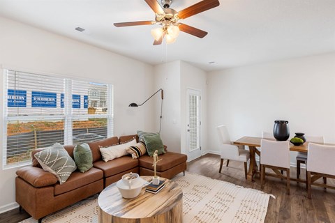A living room with a brown couch and a wooden coffee table.