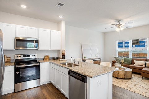 A modern kitchen with white cabinets and stainless steel appliances.