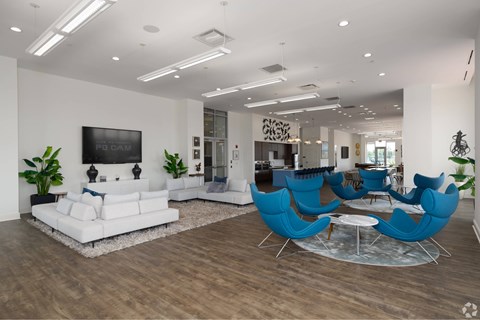 A living room with a white couch and blue chairs.