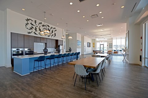 A modern kitchen with a long table and chairs.