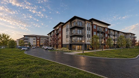 A modern apartment complex with a curved driveway in front.