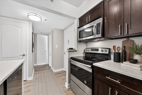A kitchen with a black stove top oven and a microwave above it.