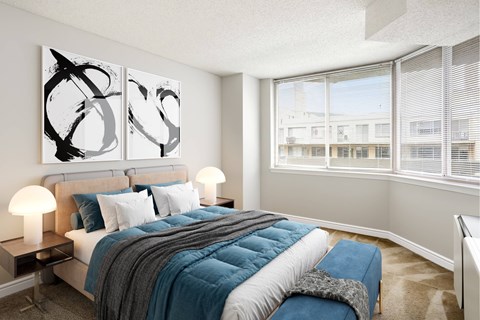 A bedroom with a large bed and two lamps.