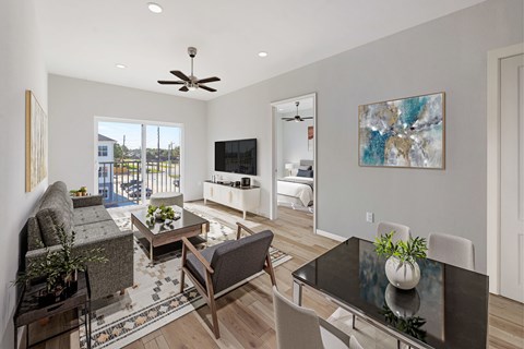 A modern living room with a grey couch, a black coffee table, and a painting on the wall.